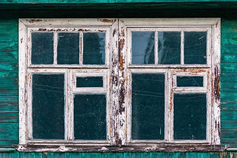 Fenêtre ancienne en bois aux volets verts