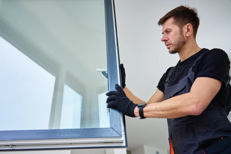 Vitrier posant une fenêtre dans une maison