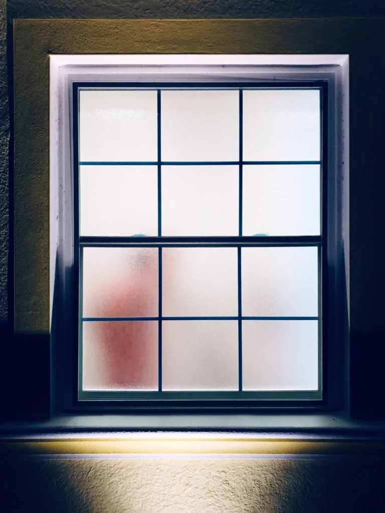 Fenêtre à petits bois éclairée la nuit